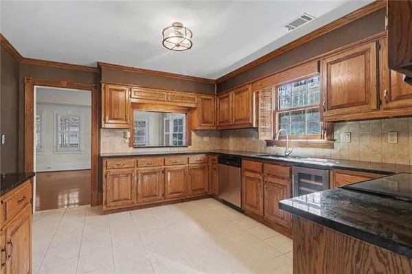 a kitchen with granite countertop a sink stove and cabinets