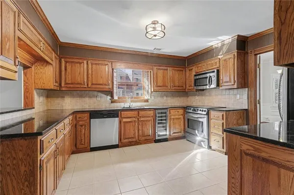 a kitchen with stainless steel appliances granite countertop a refrigerator stove microwave and sink