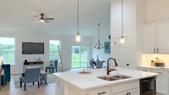 a kitchen with stainless steel appliances kitchen island a white counter space a sink and a window