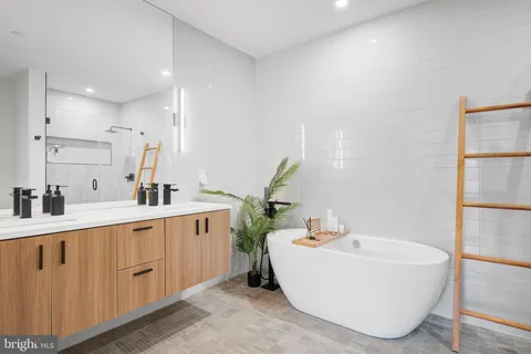 a bathroom with a sink and mirror with bathtub