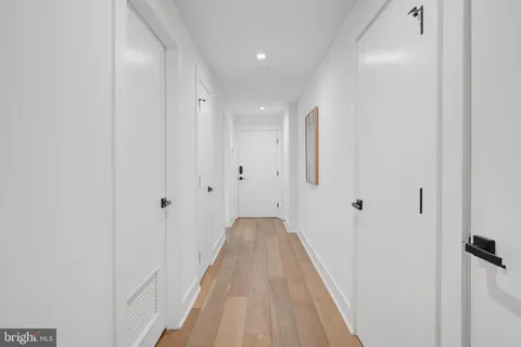a view of a hallway with wooden floor and staircase