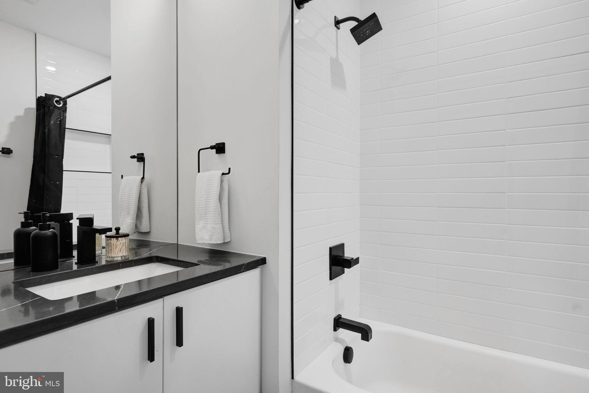 320 Webster Street Northwest, Unit 2 Washington, DC 20011 - Photo 20 of 25 a bathroom with a granite countertop sink a mirror and shower