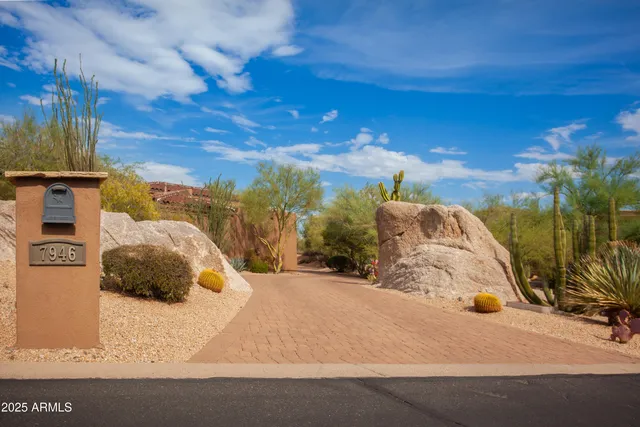 a view of the house with large trees and a wooden fence
