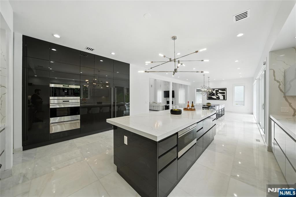 44 Floral Terrace Tenafly, NJ 07670 - Photo 11 of 49 a large kitchen with stainless steel appliances a large counter top a stove and a refrigerator