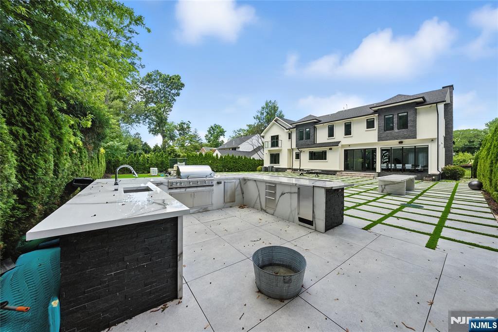 44 Floral Terrace Tenafly, NJ 07670 - Photo 32 of 49 a view of a patio with table and chairs with wooden floor and fence