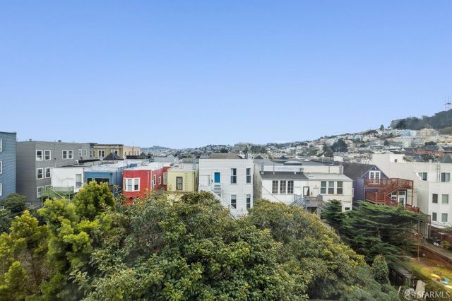 a view of a patio with table and chairs potted plants and large tree