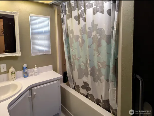 a bathroom with a sink a toilet a vanity and shower