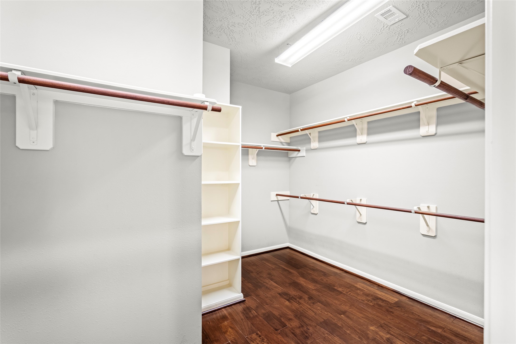5307 Amber Sky Lane Rosharon, TX 77583 - Photo 27 of 50 The oversized primary walk-in closet features rich wood flooring and generous hanging storage, closet space designed with the discerning homeowner in mind.