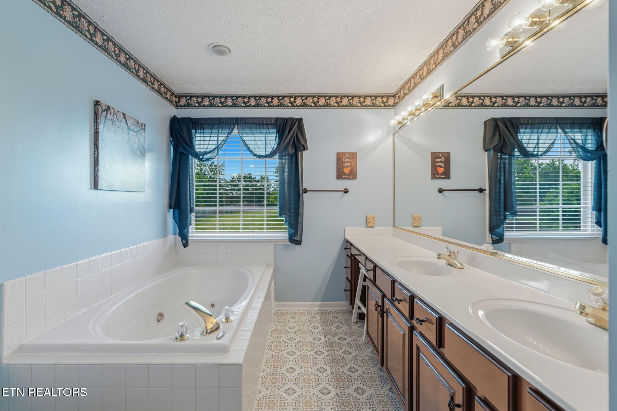 7030 Westerly Winds Road Knoxville, TN 37931 - Photo 25 of 40 a bathroom with a tub sink and mirror