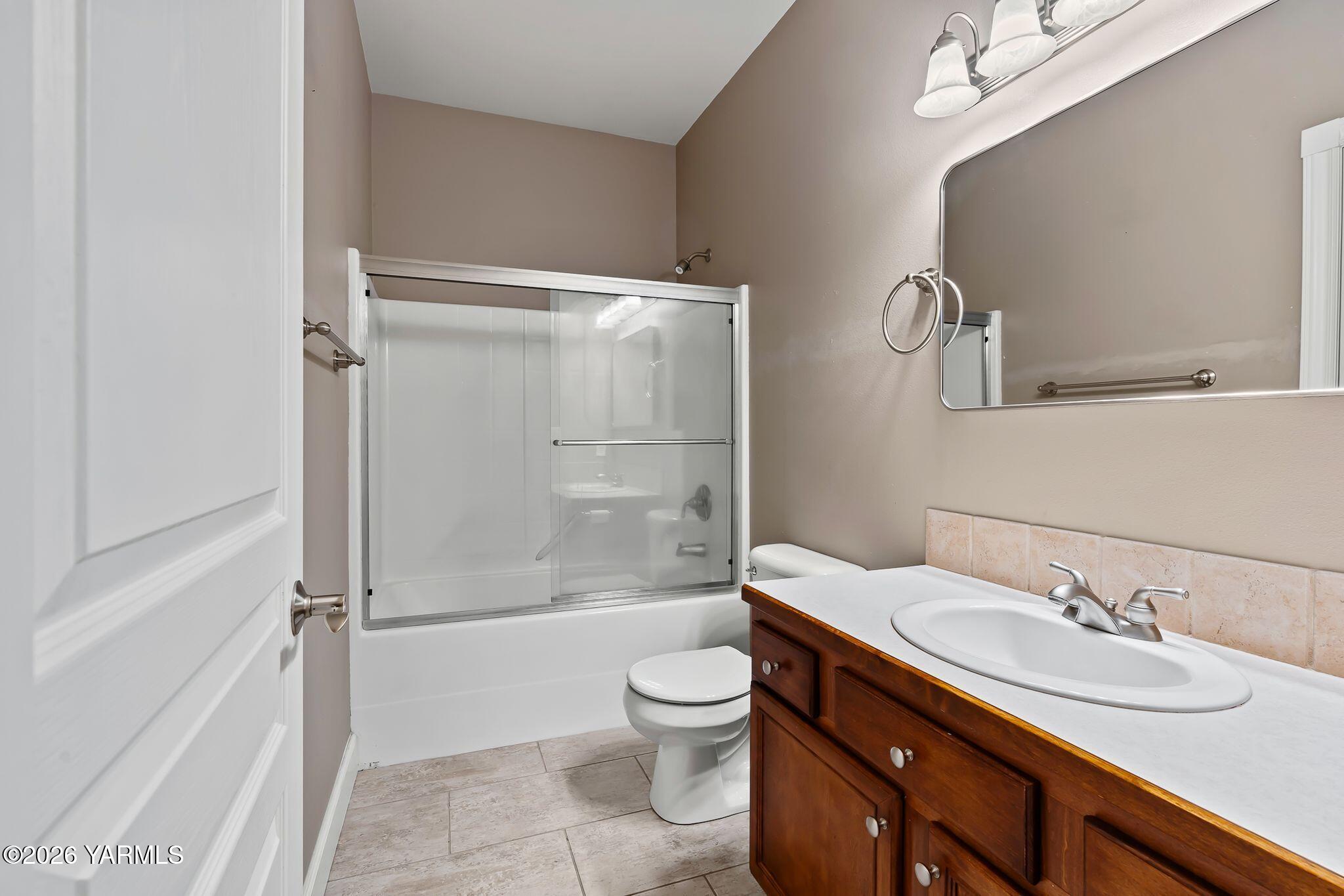 8507 Midvale Road Yakima, WA 98908 - Photo 16 of 24 a bathroom with a granite countertop sink toilet a mirror and shower