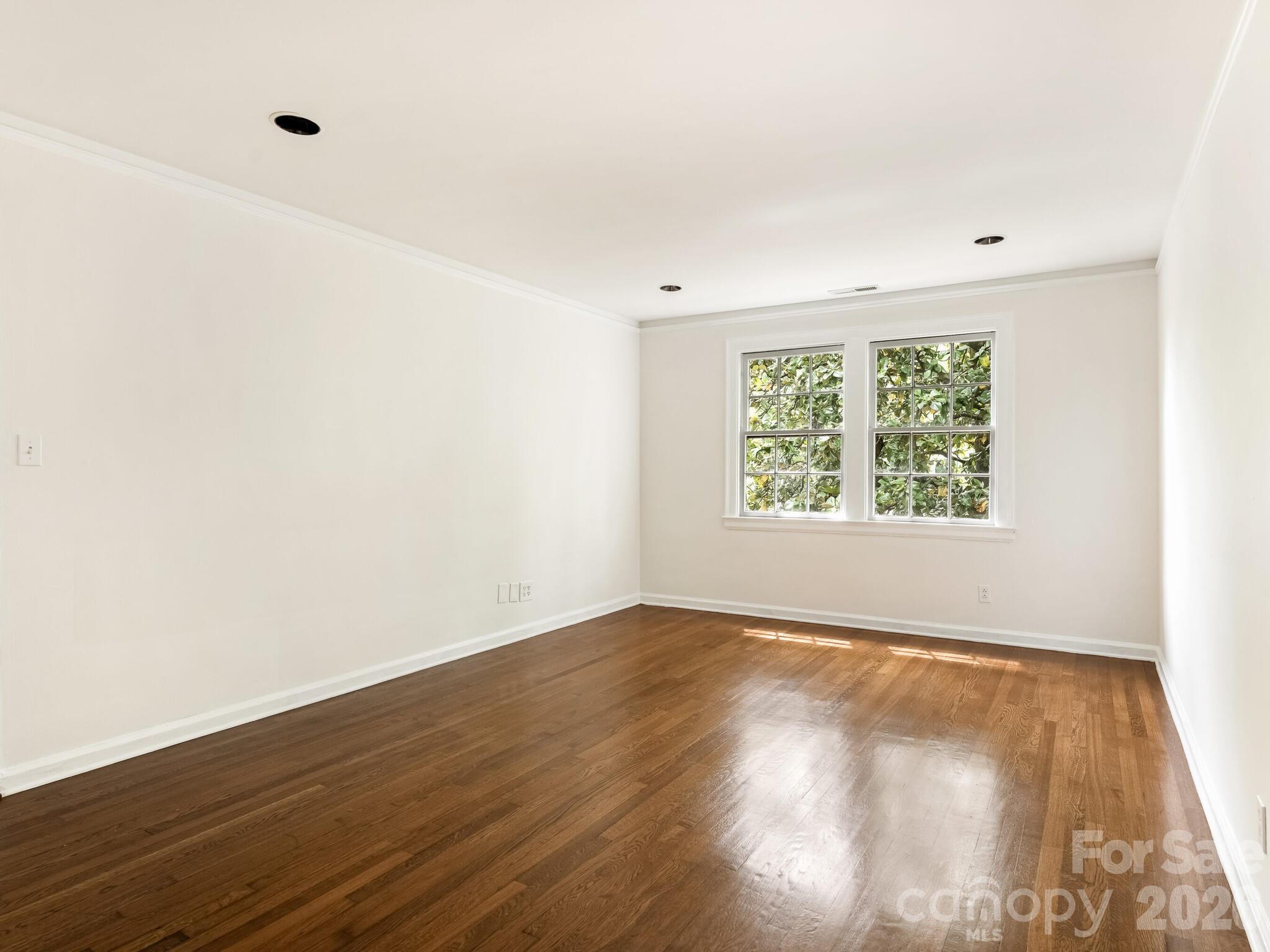 108 Colville Road, Unit 22A Charlotte, NC 28207 - Photo 4 of 14 an empty room with wooden floor and windows