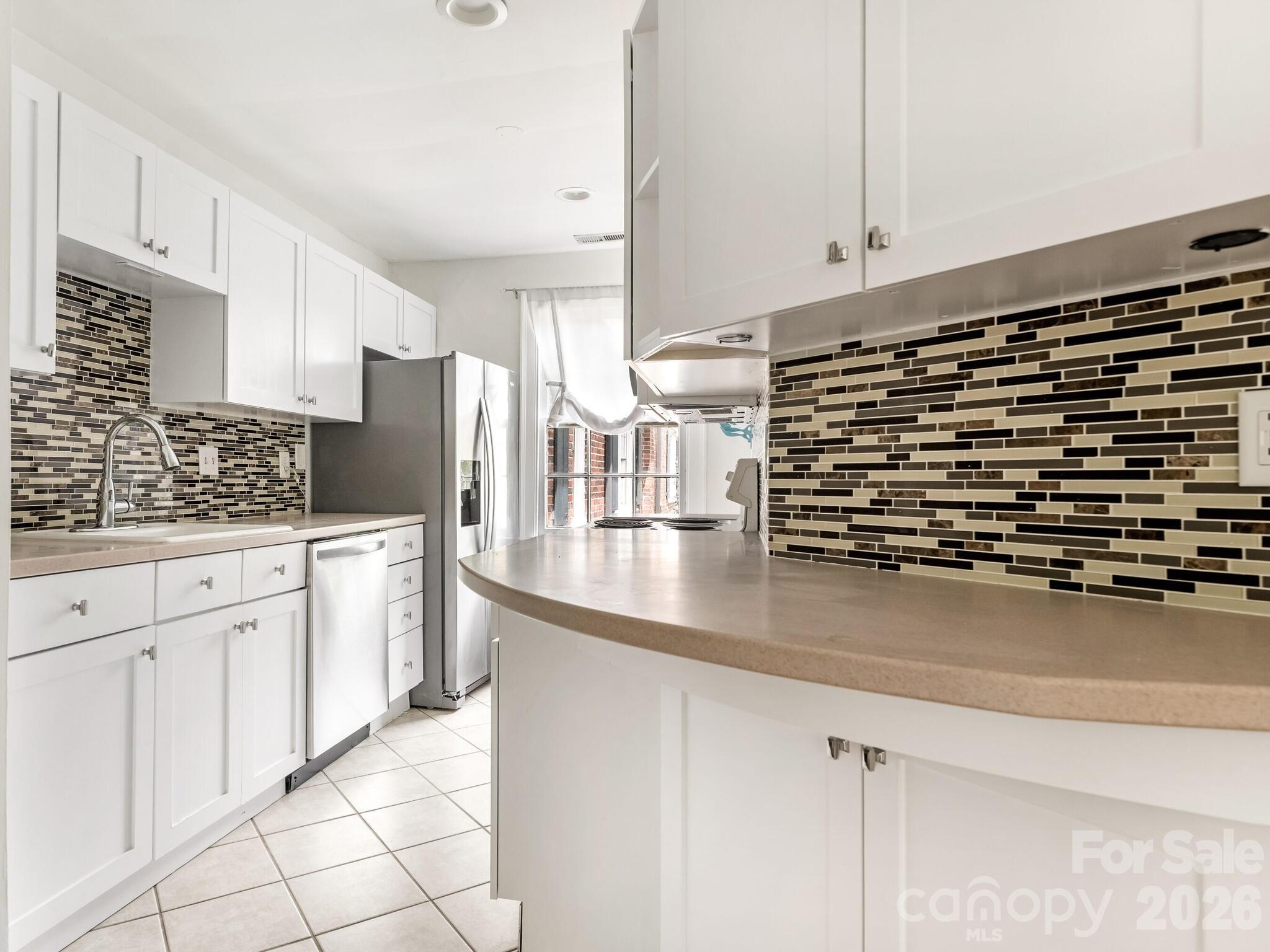 108 Colville Road, Unit 22A Charlotte, NC 28207 - Photo 6 of 14 a kitchen with stainless steel appliances a sink and cabinets