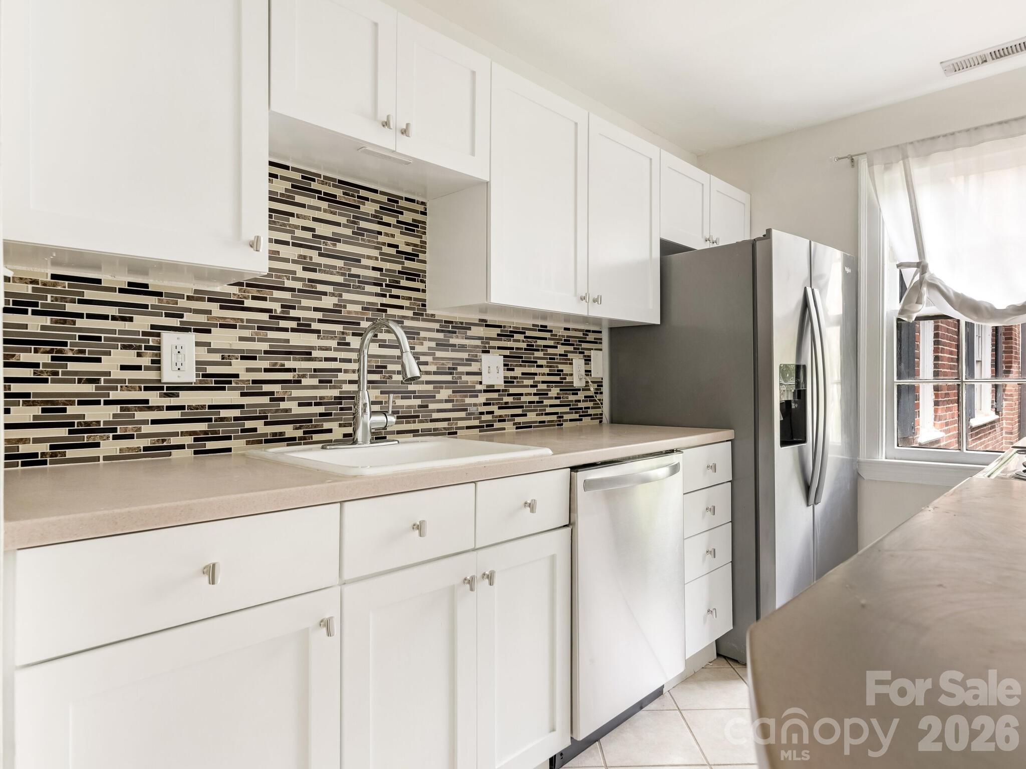 108 Colville Road, Unit 22A Charlotte, NC 28207 - Photo 7 of 14 a kitchen with granite countertop white cabinets and stainless steel appliances