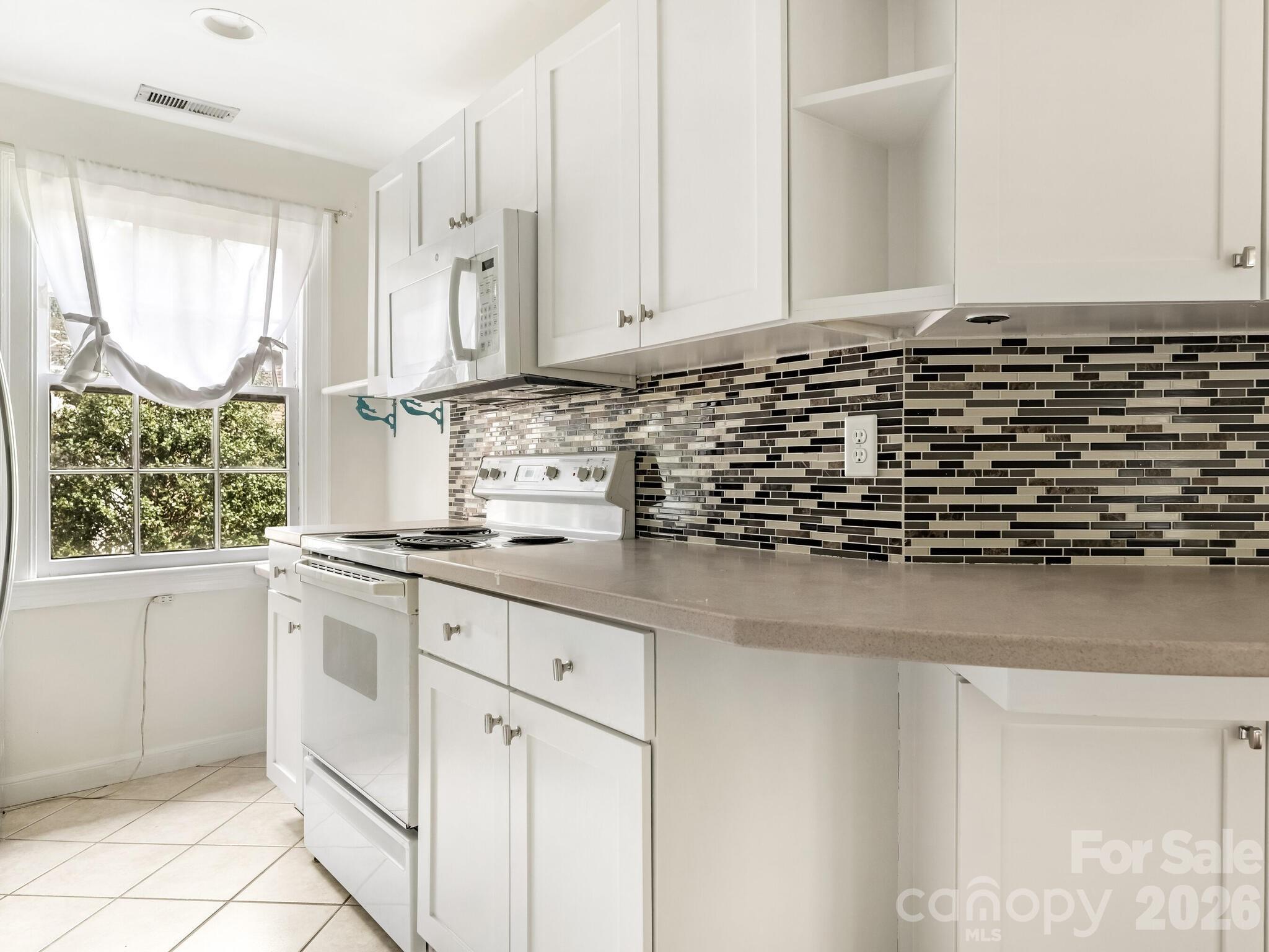 108 Colville Road, Unit 22A Charlotte, NC 28207 - Photo 8 of 14 a kitchen with granite countertop white cabinets and white appliances