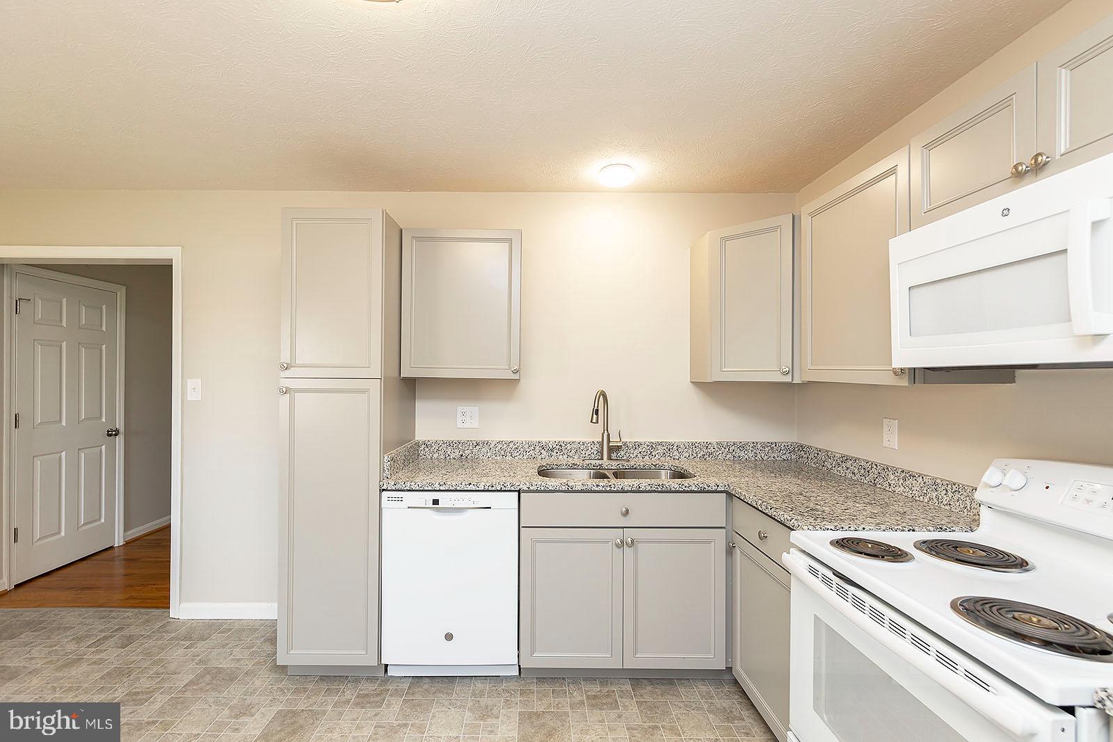 174 Double Church Road Stephens City, VA 22655 - Photo 11 of 29 a kitchen with white cabinets appliances and sink