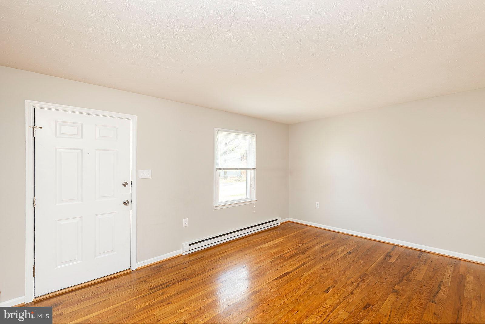 174 Double Church Road Stephens City, VA 22655 - Photo 5 of 29 an empty room with wooden floor and windows
