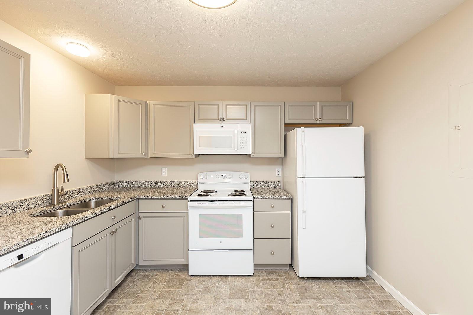 174 Double Church Road Stephens City, VA 22655 - Photo 9 of 29 a kitchen with white cabinets sink and white appliances