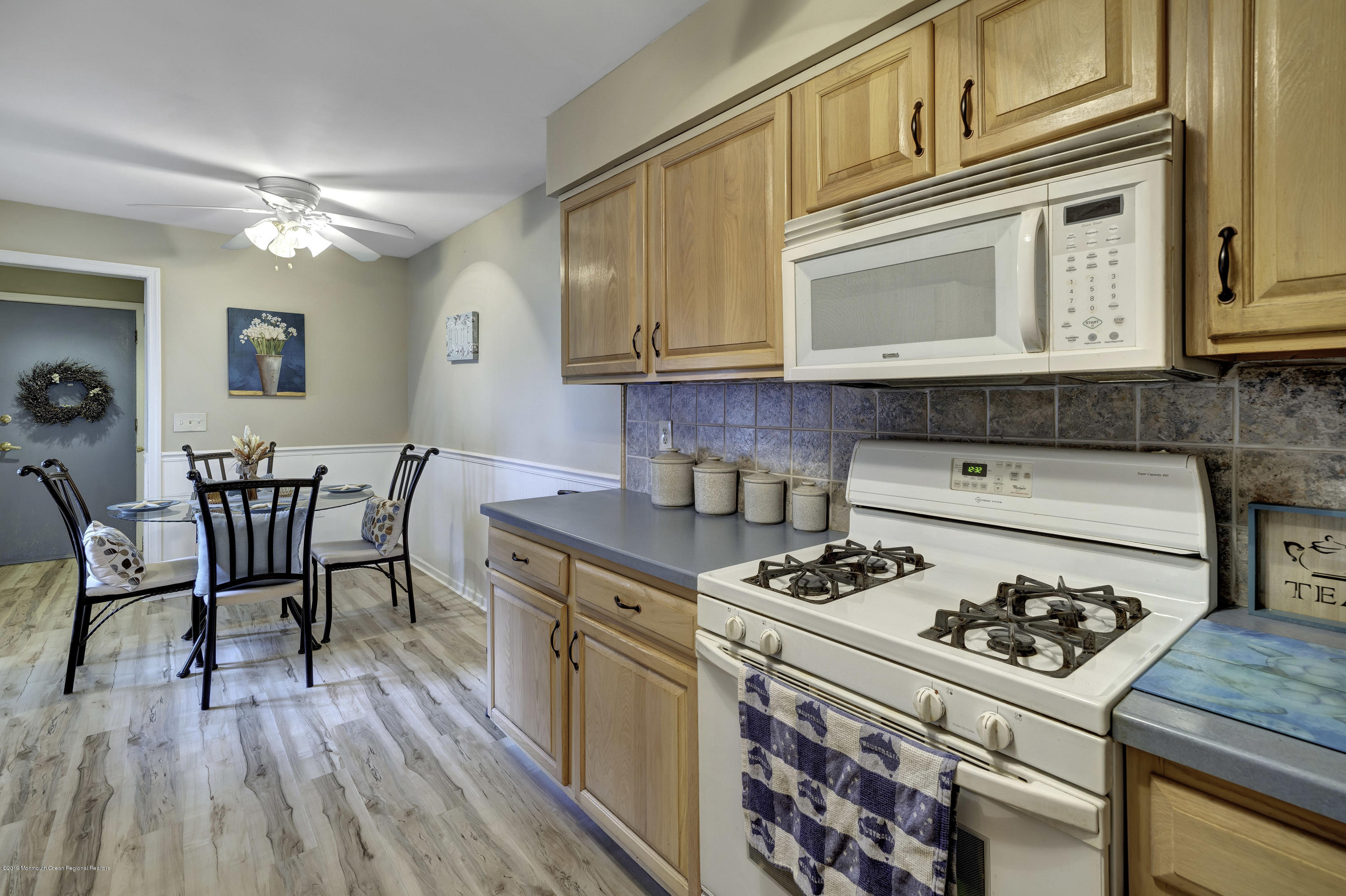 2 Cherrywood Circle, Unit 102 Brick, NJ 08724 - Photo 4 of 26 a kitchen with stainless steel appliances granite countertop a stove a sink dishwasher and cabinets with wooden floor