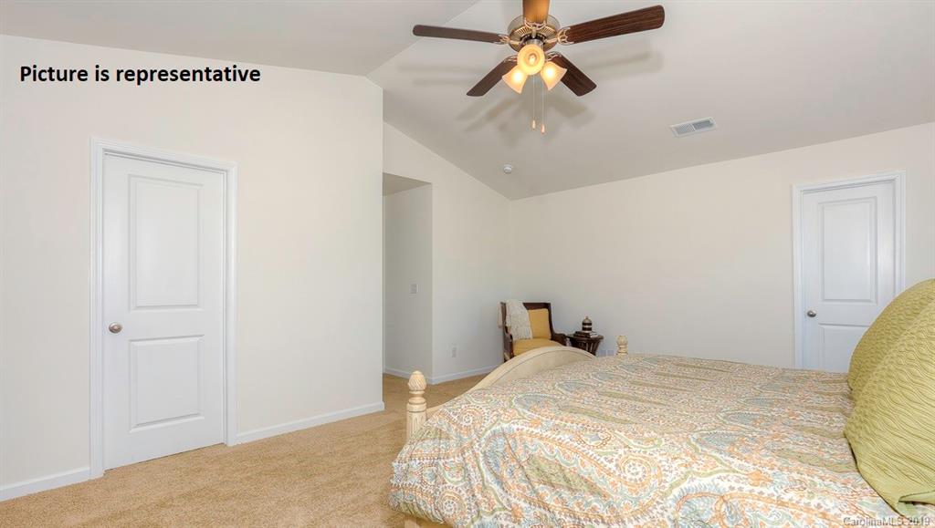 8008 Starnes Randall Road Charlotte, NC 28215 - Photo 15 of 25 a bedroom with a bed and a chandelier