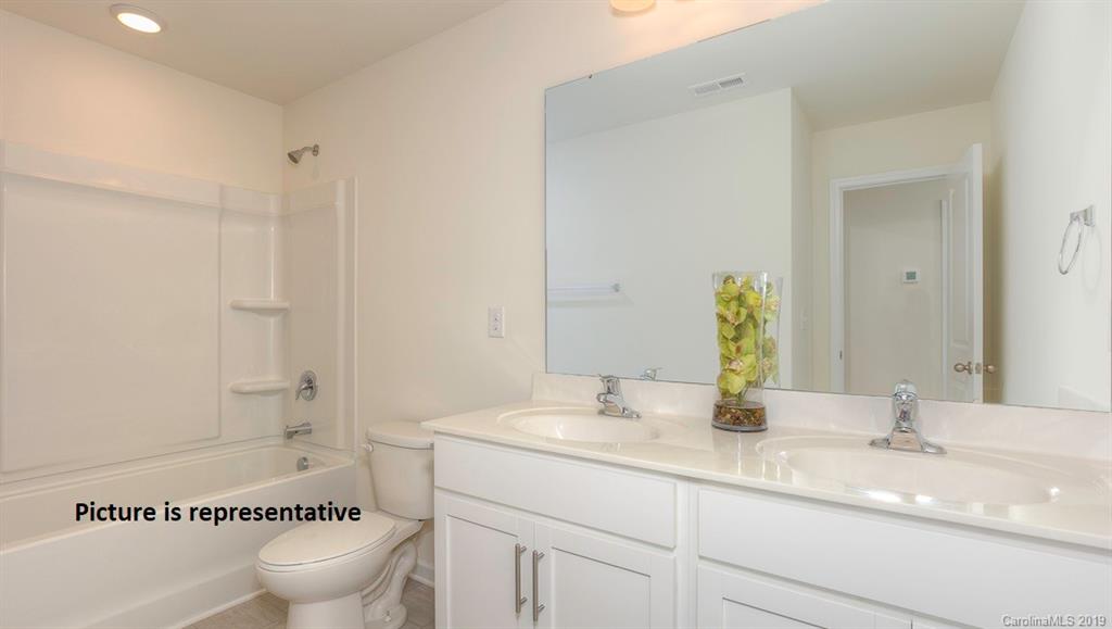 8008 Starnes Randall Road Charlotte, NC 28215 - Photo 24 of 25 a bathroom with a granite countertop sink a toilet a mirror and shower