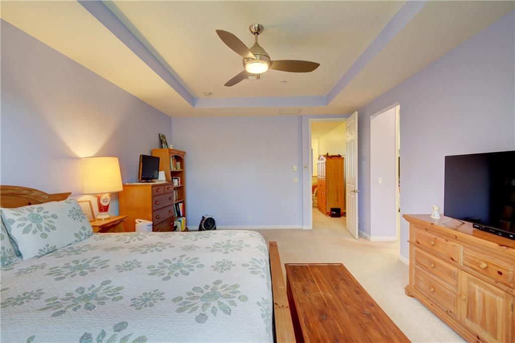 138 Southwest Walking Path Stuart, FL 34997 - Photo 26 of 50 a bedroom with a large bed and a flat tv screen on dresser