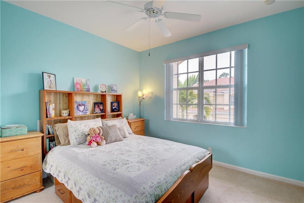 138 Southwest Walking Path Stuart, FL 34997 - Photo 33 of 50 a bedroom with a bed and a chandelier