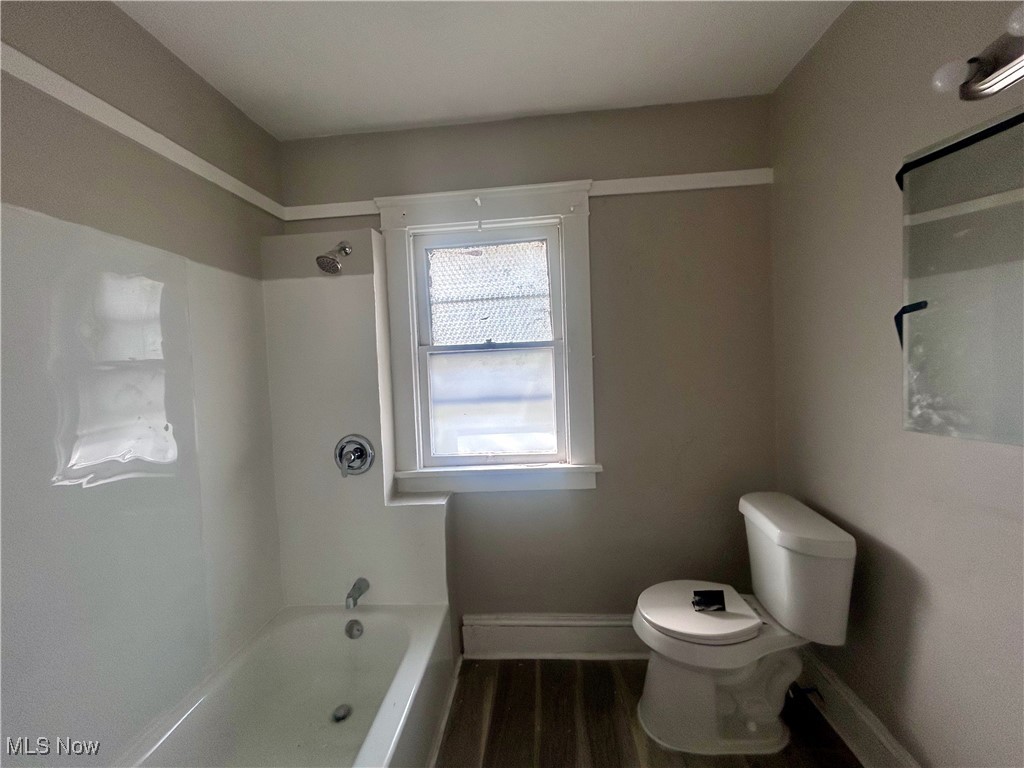 13412 Graham Road Cleveland, OH 44112 - Photo 13 of 18 Full bath with toilet, baseboards, wood finished floors, and tub / shower combination