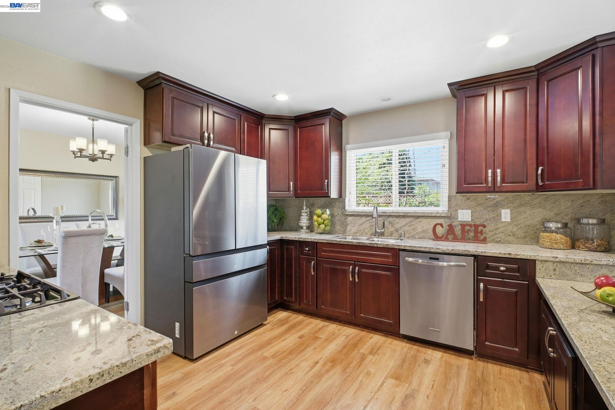 595 Seville Place Fremont, CA 94539 - Photo 9 of 43 a kitchen with stainless steel appliances granite countertop a refrigerator a sink dishwasher a stove with wooden cabinets and floor