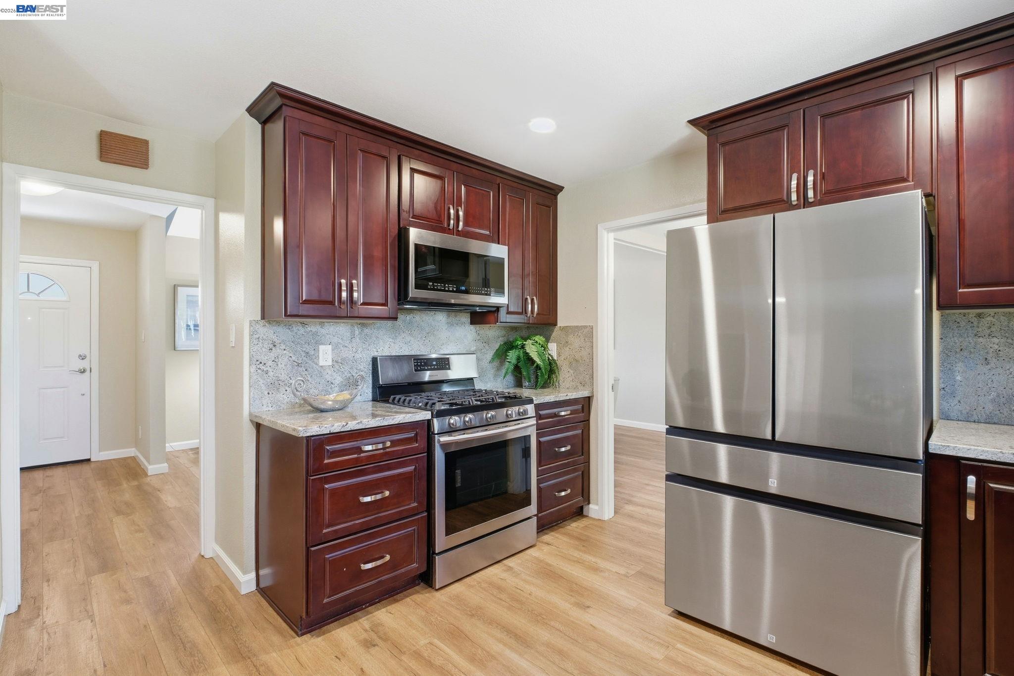 595 Seville Place Fremont, CA 94539 - Photo 10 of 43 a kitchen with stainless steel appliances granite countertop a refrigerator stove and microwave