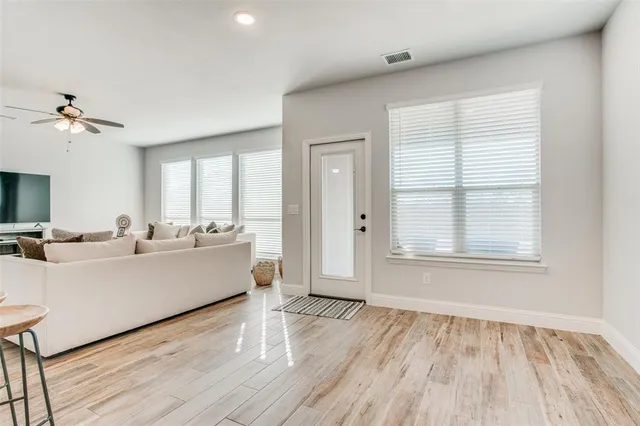 a living room with furniture and a wooden floor
