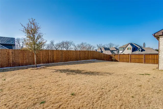 a view of a yard with wooden fence