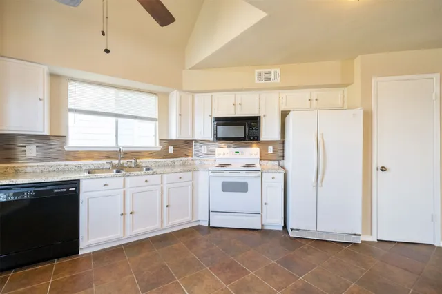 a kitchen with white cabinets and white appliances