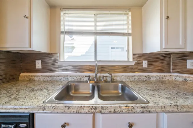a kitchen with granite countertop a sink and a window