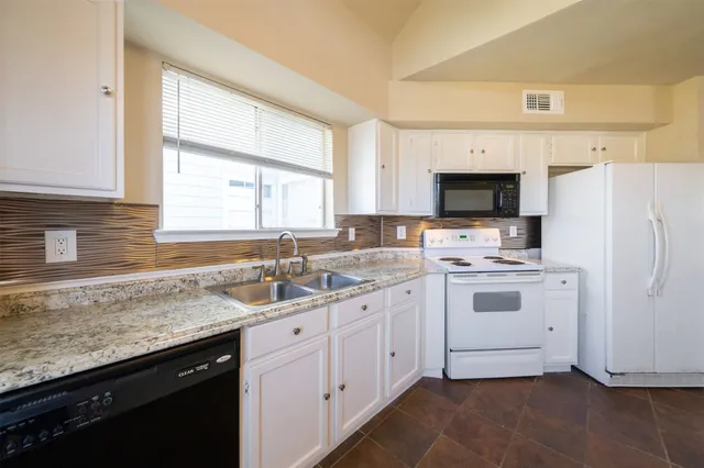 a kitchen with white cabinets sink and white appliances