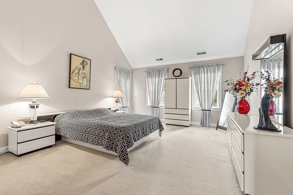 8 Rons Way Framingham, MA 01701 - Photo 18 of 33 a bedroom with a bed and a chandelier