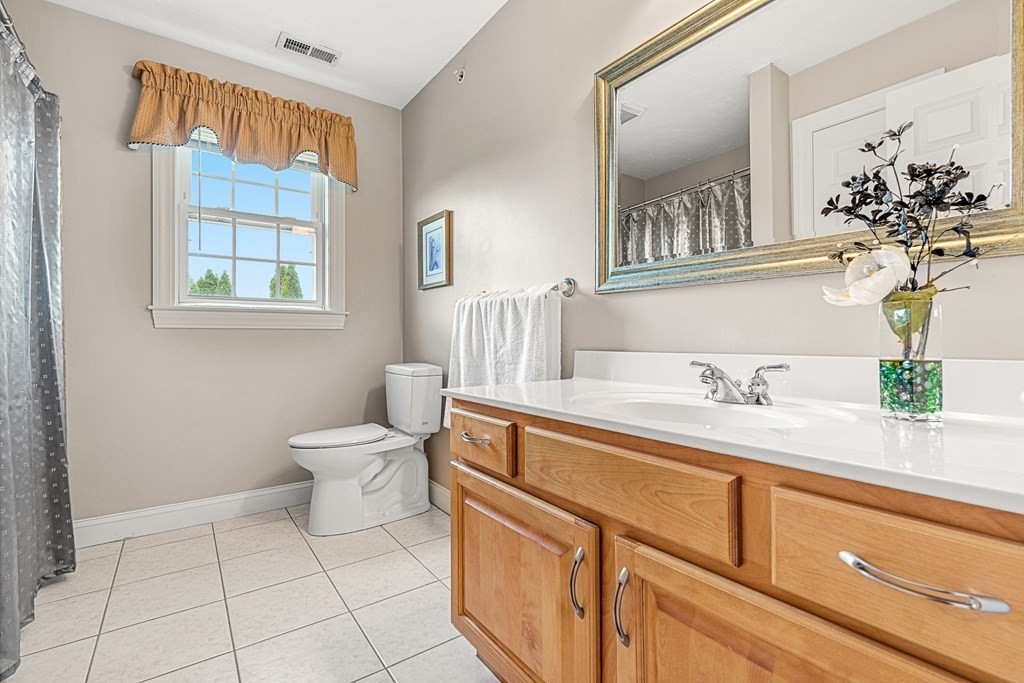 8 Rons Way Framingham, MA 01701 - Photo 24 of 33 a spacious bathroom with a granite countertop sink a toilet and a mirror