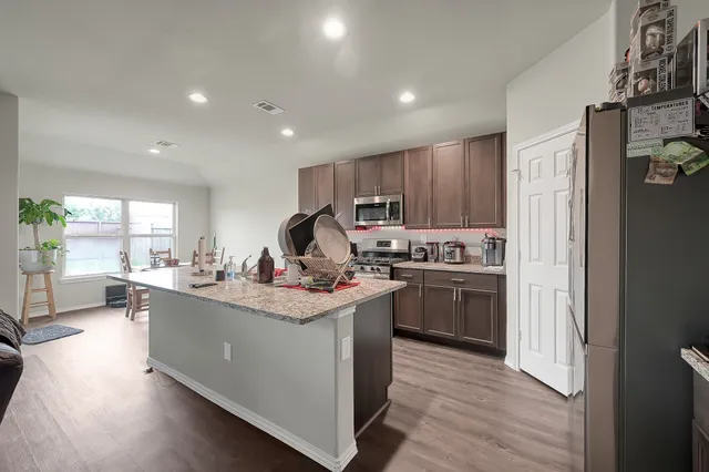 a kitchen with a sink cabinets and wooden floor