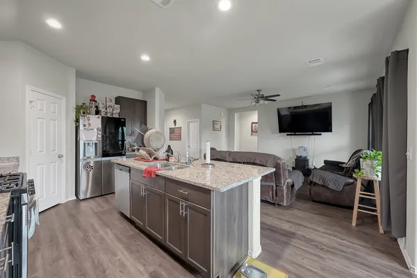 a living room with furniture a flat screen tv and a wooden floor