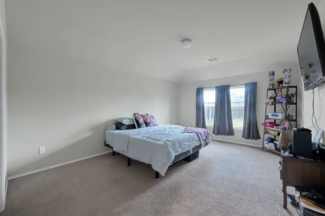 a living room with a bed furniture and a flat screen tv