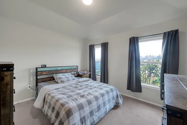a bedroom with two beds and a chair