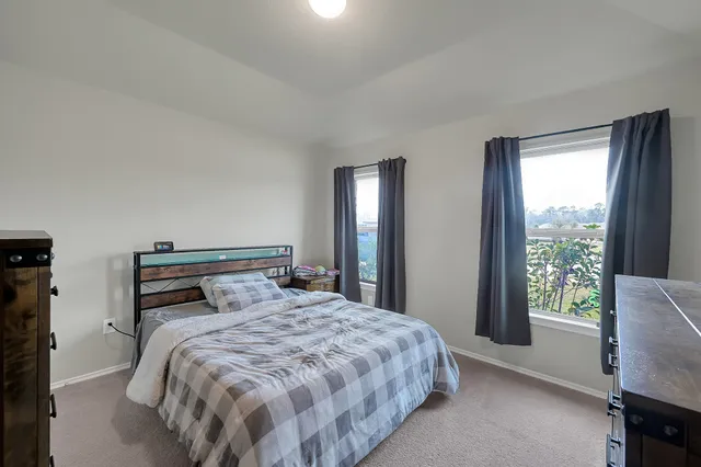 a bedroom with two beds and a chair