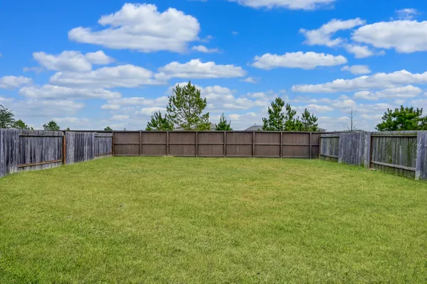 a view of yard with wooden fence