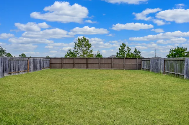 a view of yard with wooden fence