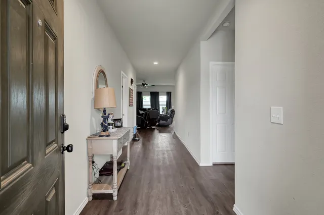 a view of a hallway with wooden floor fireplace and living room