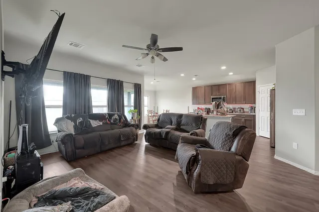 a living room with furniture and a ceiling fan