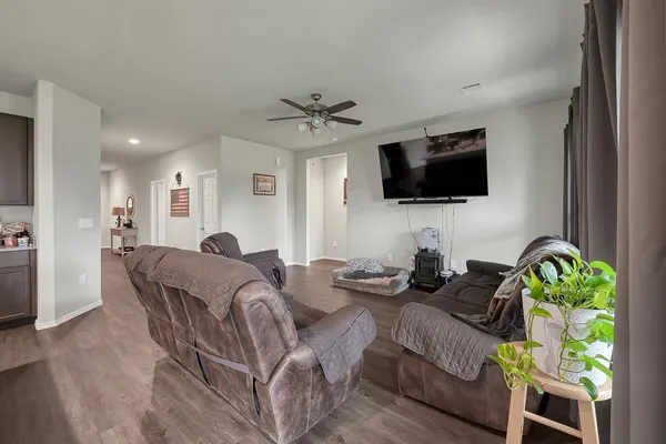 a living room with furniture a flat screen tv and a floor to ceiling window
