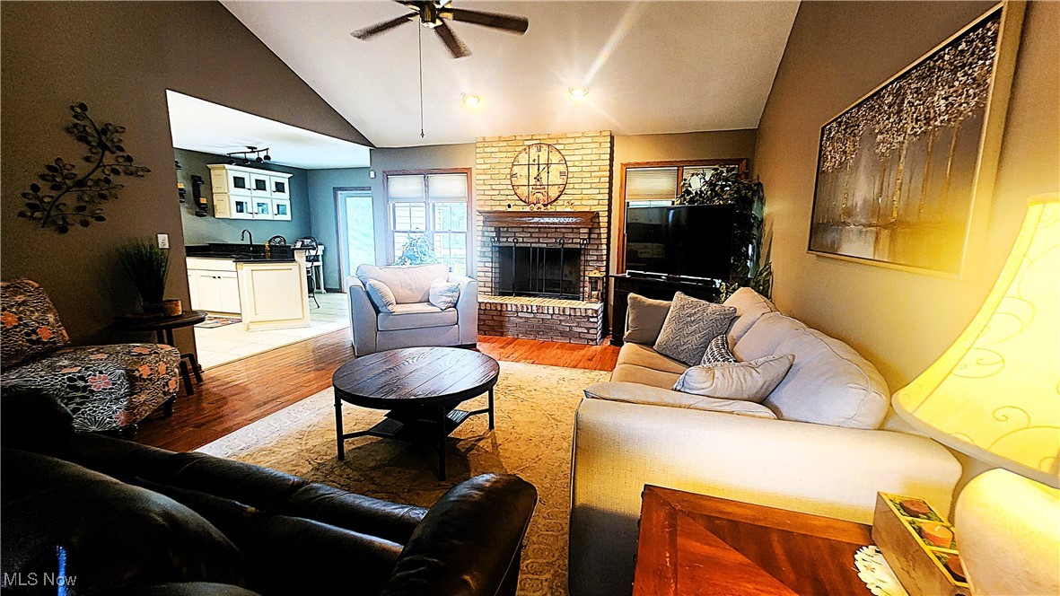 8329 Seasons Road Streetsboro, OH 44241 - Photo 15 of 35 Living room featuring hardwood / wood-style floors, ceiling fan, vaulted ceiling, and a fireplace