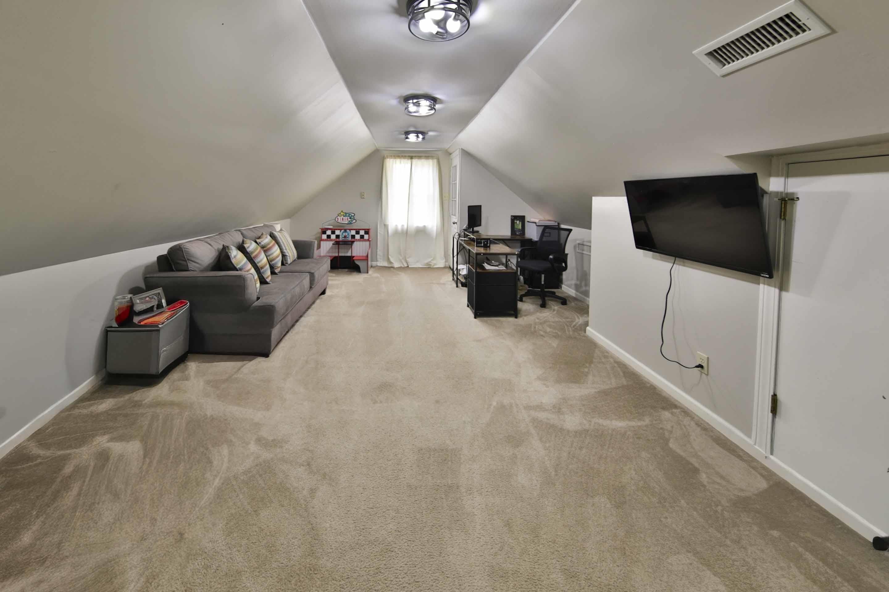 104 Miller Road Covington, TN 38019 - Photo 23 of 25 Spacious carpeted room featuring sloped ceilings, recessed lighting, and a window with natural light