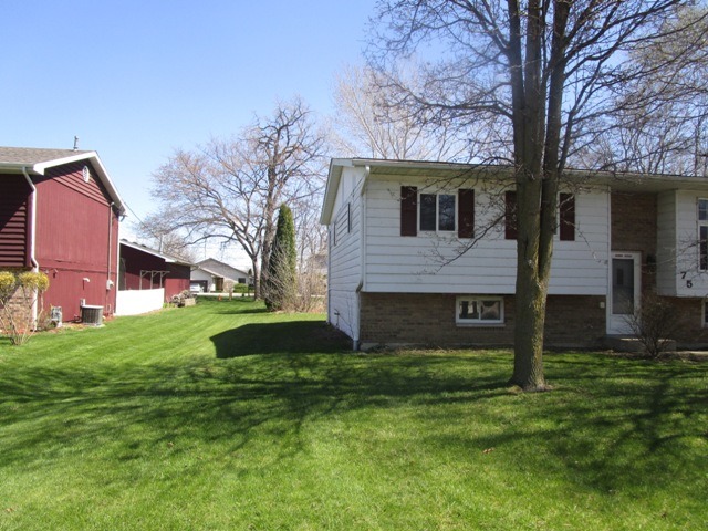 75 Tweed Road Fox Lake, IL 60020 - Photo 2 of 17 a front view of a house with garden