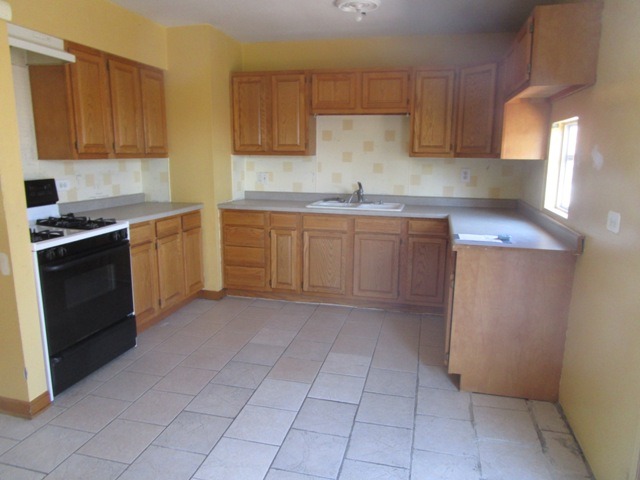 75 Tweed Road Fox Lake, IL 60020 - Photo 6 of 17 a kitchen with a stove sink and cabinets
